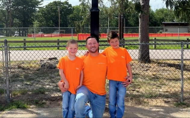 A man and two boys standing on a sports court