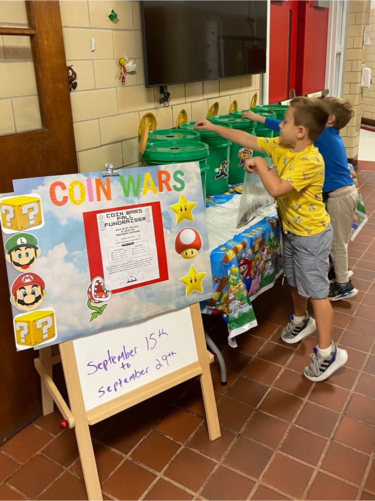 Students adding money to the Coin War buckets